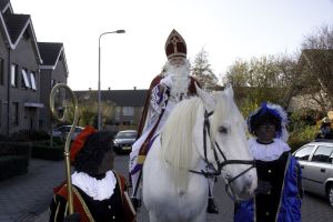 Sinterklaas on his white horse, accompanied by two Black Petes \br (Flickr Creative Commons)