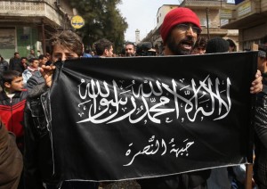 Credits: The Japan Times Protestors demonstrate against Bashar Al-Assad while holding Al-Nusra flags