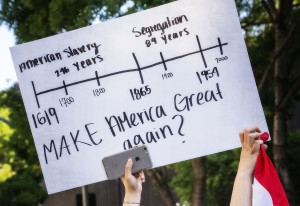 Protestors hold up a sign at a rally. Photo Credit: https://flic.kr/p/Hzb1Jq